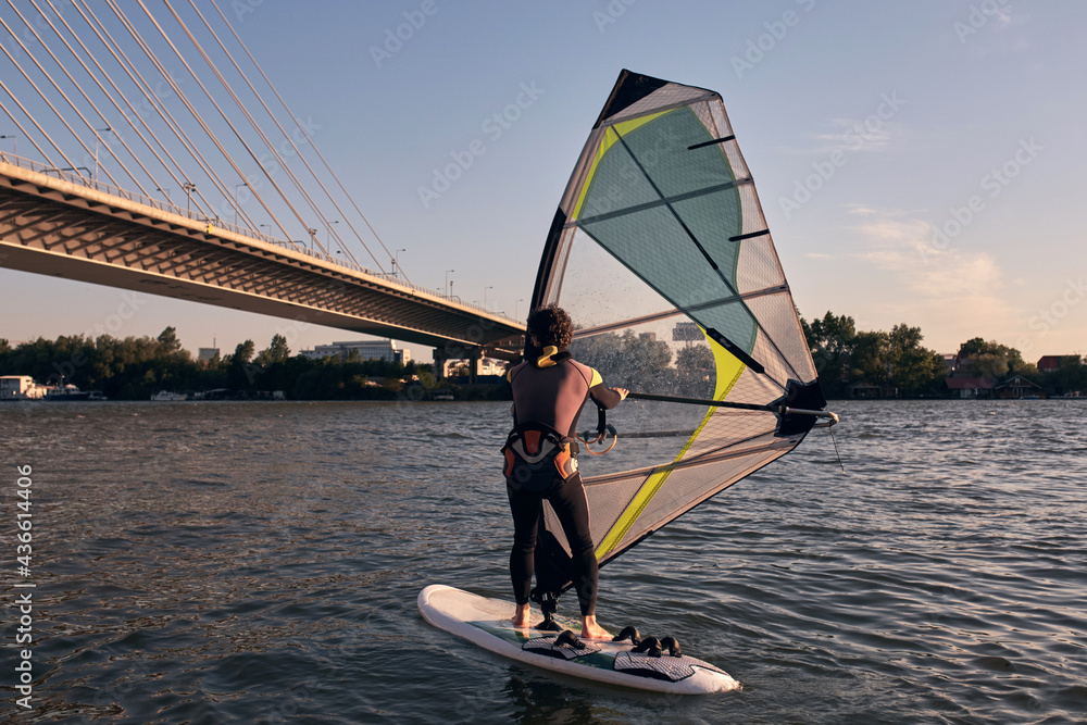 Naklejka premium Windsurfer surfing on a windy day at the river.