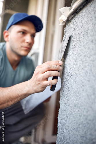 Man working on a house facade.