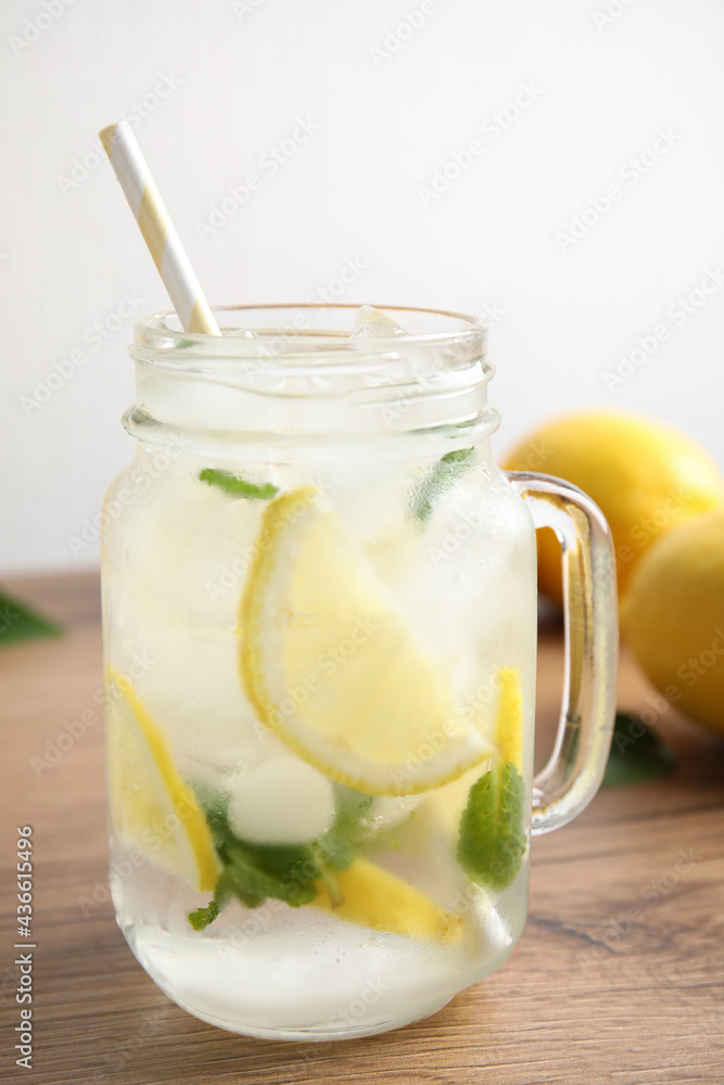 Mason jar of cold lemonade on wooden table Mason jar of cold lemonade on wooden table