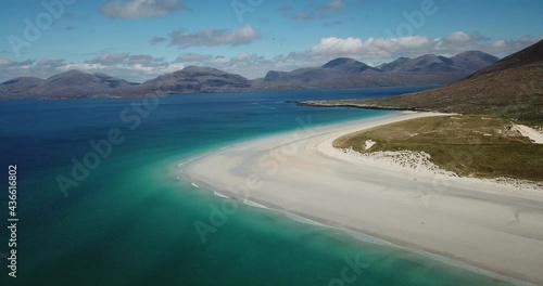 4k aerial footage of Luskentyre beach, Isle of Lewis, Outer Hebrides, Scotland. Sunny day with blue sky and white clouds. White sand, turquoise and blue water, sand dunes, mountains. Stunning scenery. photo
