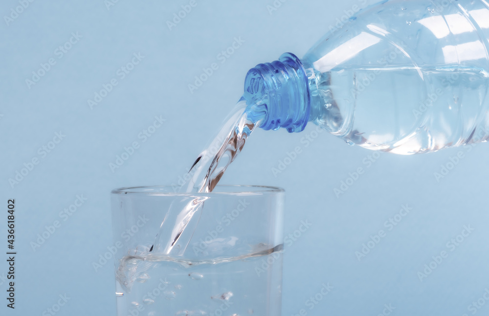 Pouring water from a plastic bottle into a glass. Pouring water from a plastic bottle into a glass.