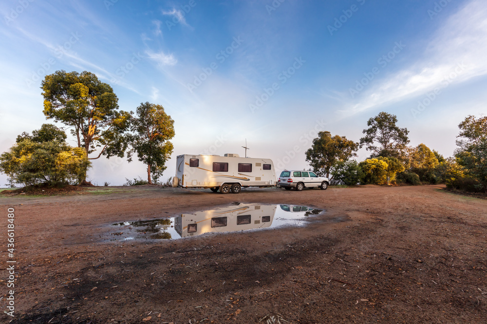 Landscape view of a large modern caravan and fourwheel drive camped near trees and a lake on a foggy morning near Collie in Western Australia - obrazy, fototapety, plakaty 