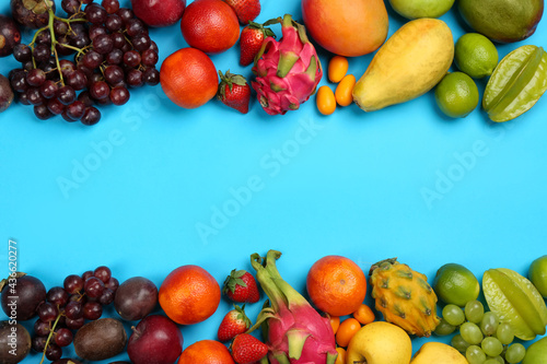 Assortment of fresh exotic fruits on light blue background  flat lay. Space for text