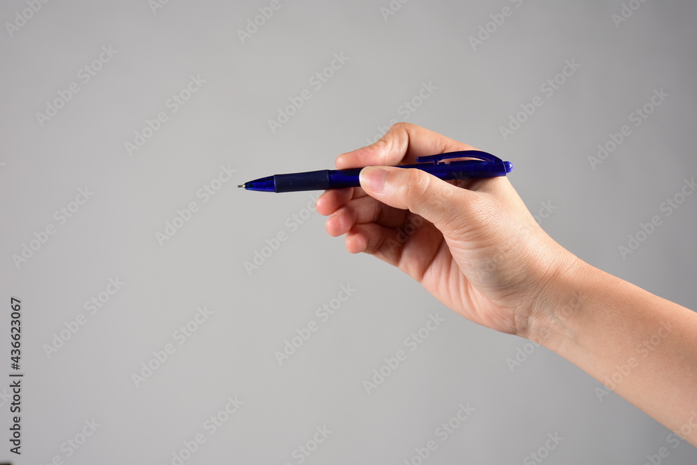 hand holding pen isolated on grey background hand holding pen isolated on grey background