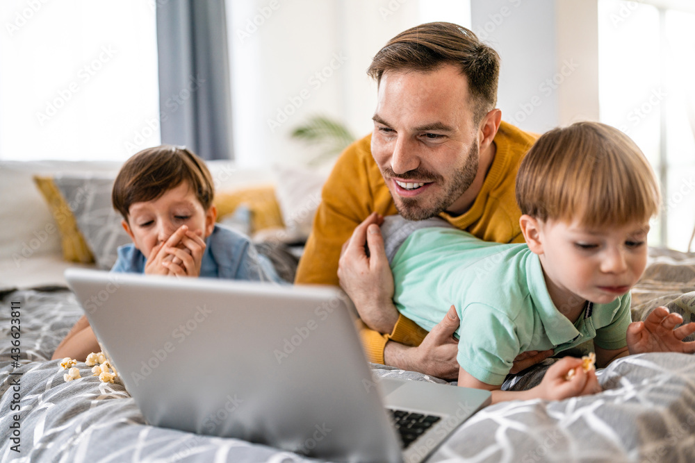 Happy family at home looking at laptop and having fun Happy family at home looking at laptop and having fun
