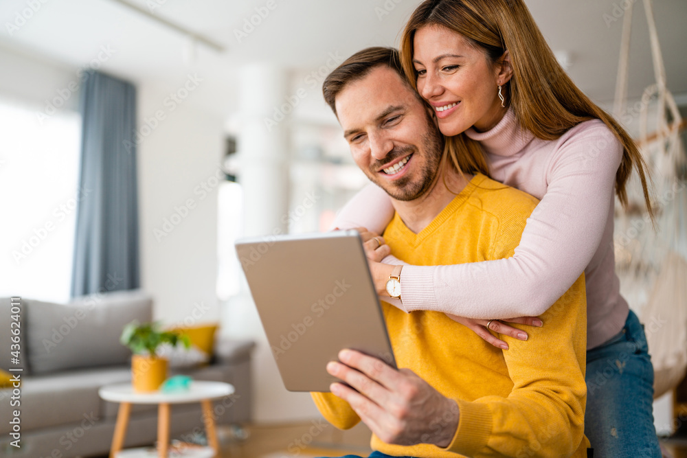 Happy couple spending time with tablet at home Happy couple spending time with tablet at home