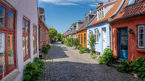Fototapeta Naklejka Na Ścianę i Meble -  Aarhus, Denmark; May 30th, 2021 - Colourful old cottages on a quiet street in Aarhus, Denmark