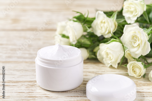 Moisturizing cream for sensitive skin, spa cosmetic and natural clean skincare product on a background of white roses.
