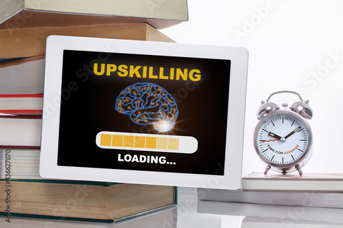 Upskilling loading with brain on digital computer tablet with stack of textbook with time to change words on alarm clock isolated on white background. Technology concept and time management idea