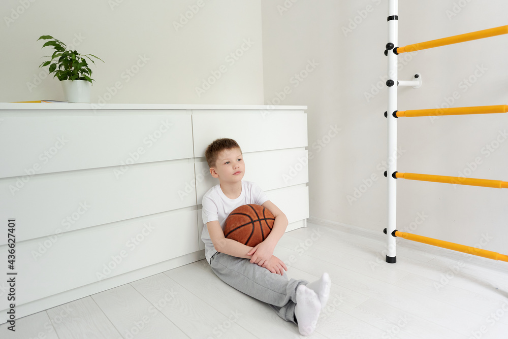 A preschool boy sitting on the floor at his room A preschool boy sitting on the floor at his room