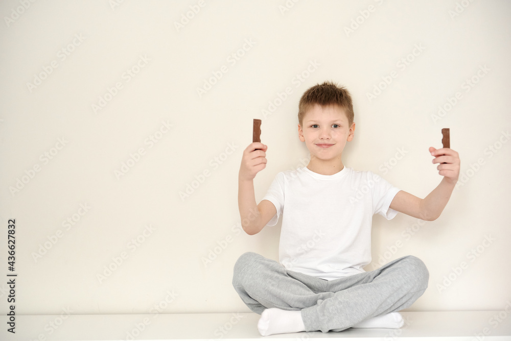 Cute smiling boy in casual clothes sitting on the dresser Cute smiling boy in casual clothes sitting on the dresser