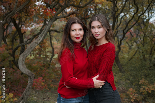 Mature mother hugging with her teen daughter outdoor in nature