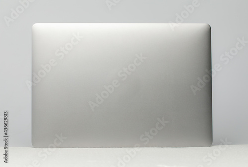 Flat silver light weight  notebook computer standing up showing luxury design. Display as isolated on white background.