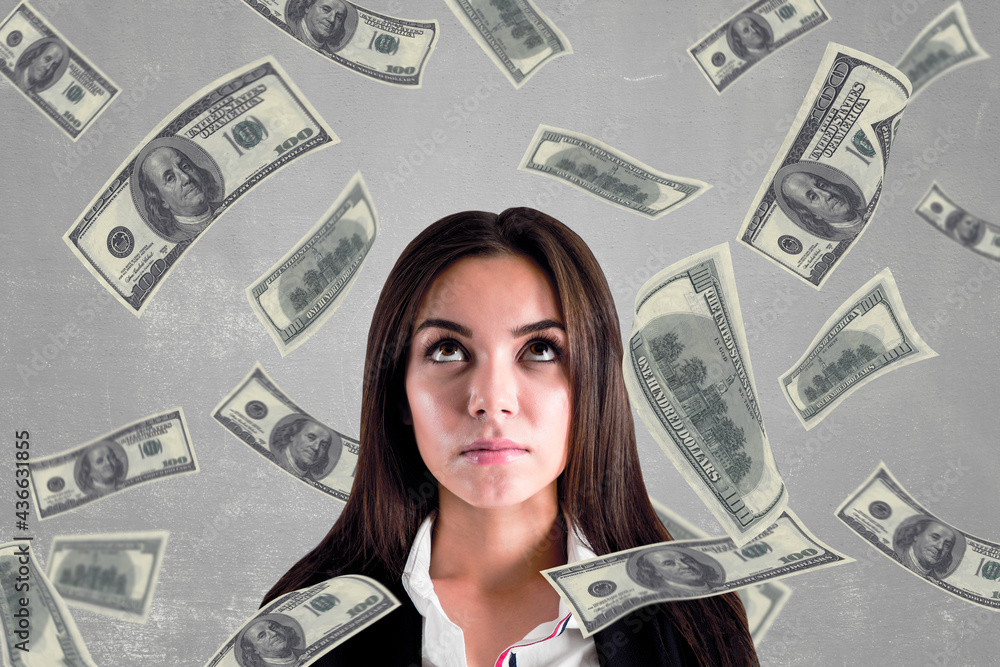 Earning money concept with young woman surrounded by dollar bills at abstract backdrop. Earning money concept with young woman surrounded by dollar bills at abstract backdrop.
