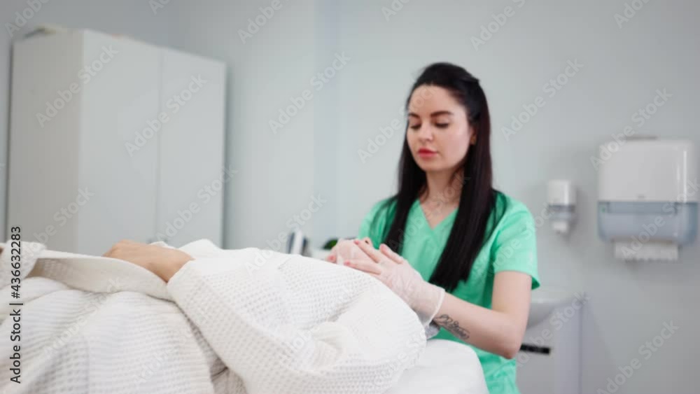 Woman Professional beautician makes facial skin care procedures to a female patient in a beauty salon. Wellness health care body massage spa concept. Anti-aging treatment. Woman Professional beautician makes facial skin care procedures to a female patient in a beauty salon. Wellness health care body massage spa concept. Anti-aging treatment.