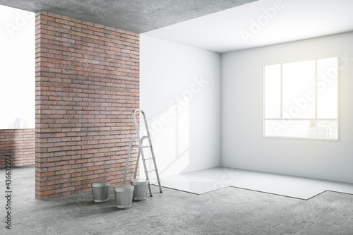 Sunny renovation room in light apartment with brick and white walls and ladder with buckets on concrete floor photo