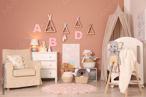 Baby room interior with stylish furniture and comfortable crib photo