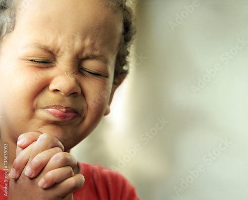 boy praying to God with hands together stock photo