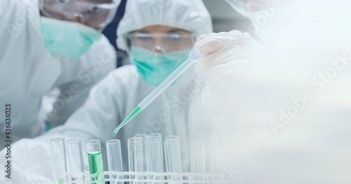 Composition of scientists in ppe suits with test tubes working in laboratory and copy space