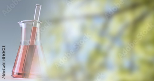 Composition of red liquid and stirrer in flask, with blurred tree copy space to right