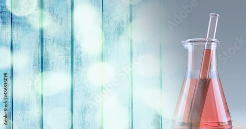 Composition of conical flask of red liquid and stirrer, with blurred bokeh copy space