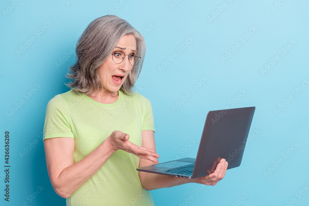 Naklejka premium Photo of shocked angry unhappy old woman look laptop deadline isolated on pastel blue color background