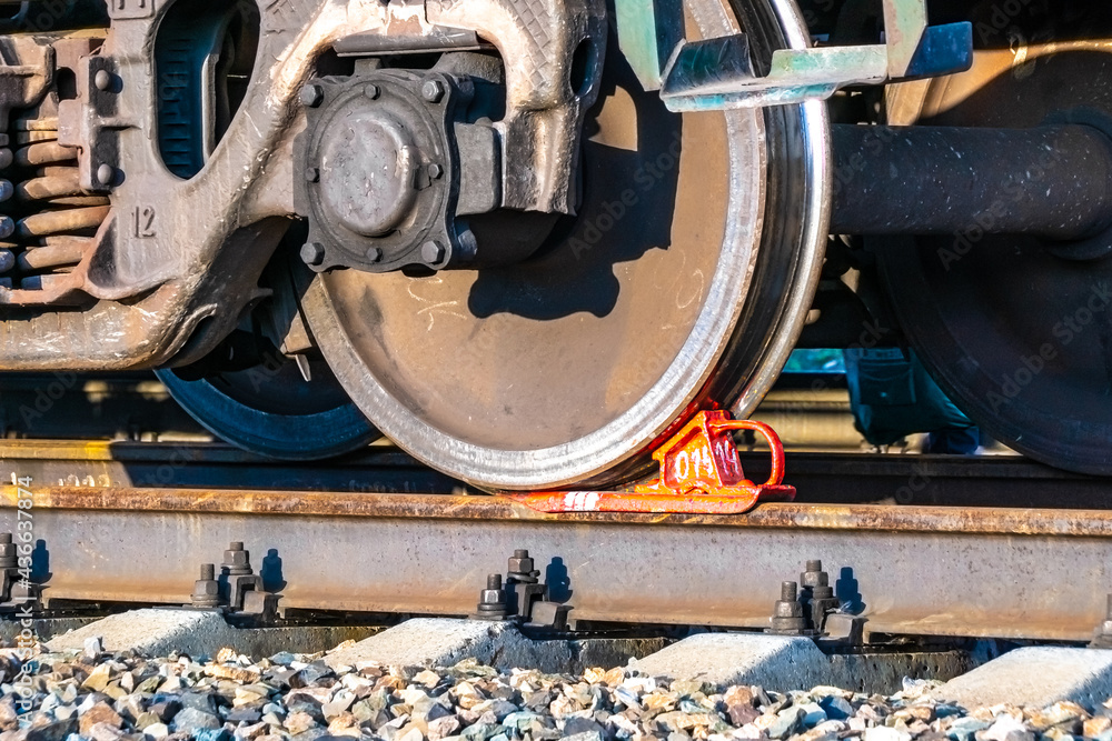 railway brake shoe under the wheel of a railway carriage standing on a siding, awaiting cargo departure or waiting for an empty carriage to be loaded