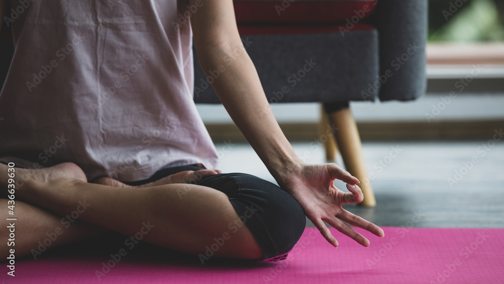 Naklejka premium Two ladies in living room sitting on floor doing asana position one of yoga figure. Activity like Buddhism meditation help to relax. New lifestyle for girls.