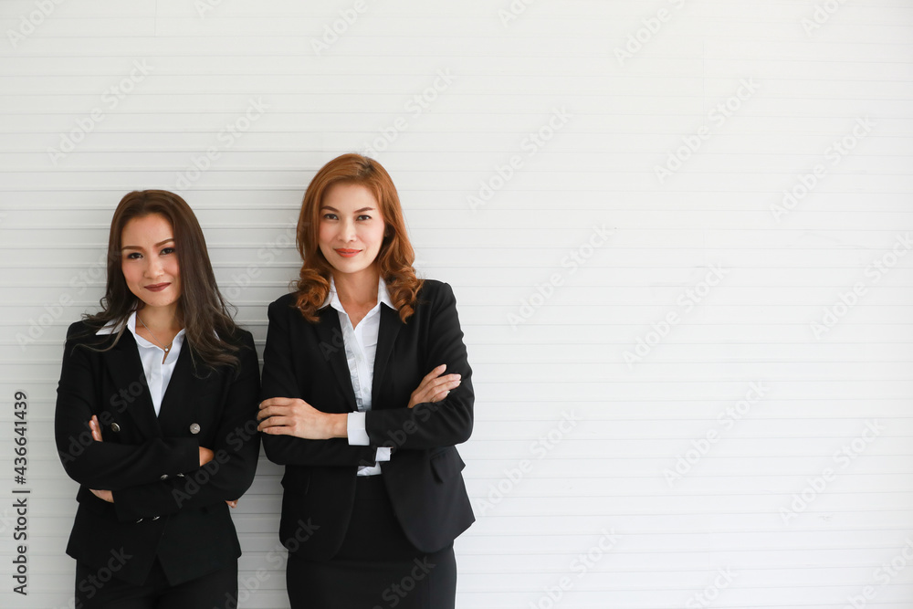 Confident Asian businesswomen against gray wall Confident Asian businesswomen against gray wall