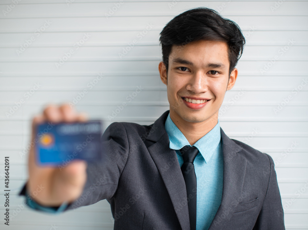 Cheerful Asian businessman advertising credit card Cheerful Asian businessman advertising credit card