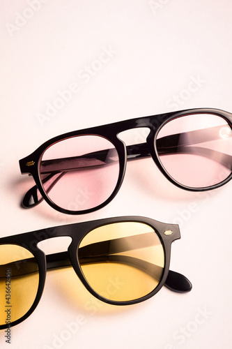 Trendy pink and yellow sunglasses with black frame or rim with shiny reflection