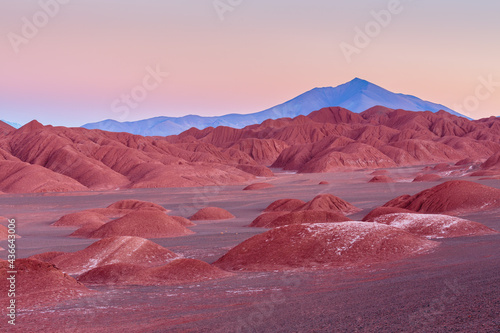 Desolate desert landscape with strongly eroded badlands in the vicinity of Tolar Grande on the high altitude plateau of the puna in northwest Argentina in the blue hour before sunrise photo