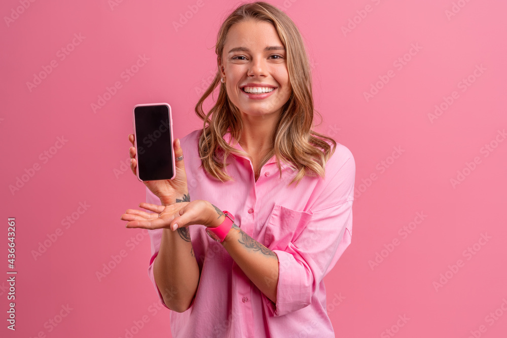 blond pretty woman in pink shirt smiling holding holding using smartphone blond pretty woman in pink shirt smiling holding holding using smartphone