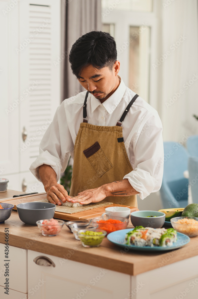Chef takes rice for sushi rolls. Preparing ingredients for making sushi. Food delivery online service. Japanese cuisine: rolls, soy sauce, wasabi. Promo for restaurant Chef takes rice for sushi rolls. Preparing ingredients for making sushi. Food delivery online service. Japanese cuisine: rolls, soy sauce, wasabi. Promo for restaurant