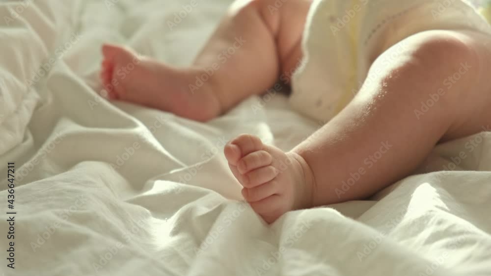 Tiny Human Feet of Caucasian Neonate Toddler is in Focus. Authentic Close Up Footage of Newborn Baby Lying on the Back. Concept of Childhood, New Llife and Maternity. Baby feet in mother's hands. Tiny Human Feet of Caucasian Neonate Toddler is in Focus. Authentic Close Up Footage of Newborn Baby Lying on the Back. Concept of Childhood, New Llife and Maternity. Baby feet in mother's hands.