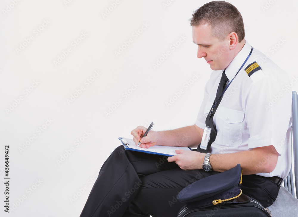 © Monika Wisniewska - Airline captain pilot fills out the paperwork before the flight © Monika Wisniewska - Airline captain pilot fills out the paperwork before the flight