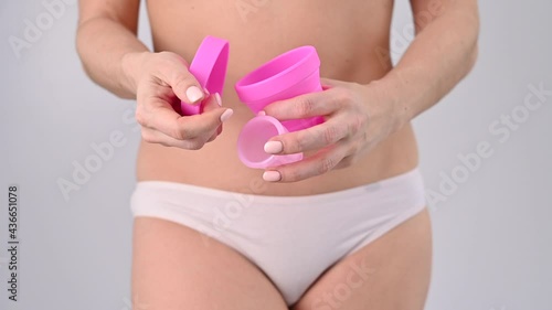 Wallpaper Mural A faceless caucasian woman in underpants takes out a pink menstrual cup into a container for sterilization. An alternative means of feminine intimate hygiene during menstruation Torontodigital.ca