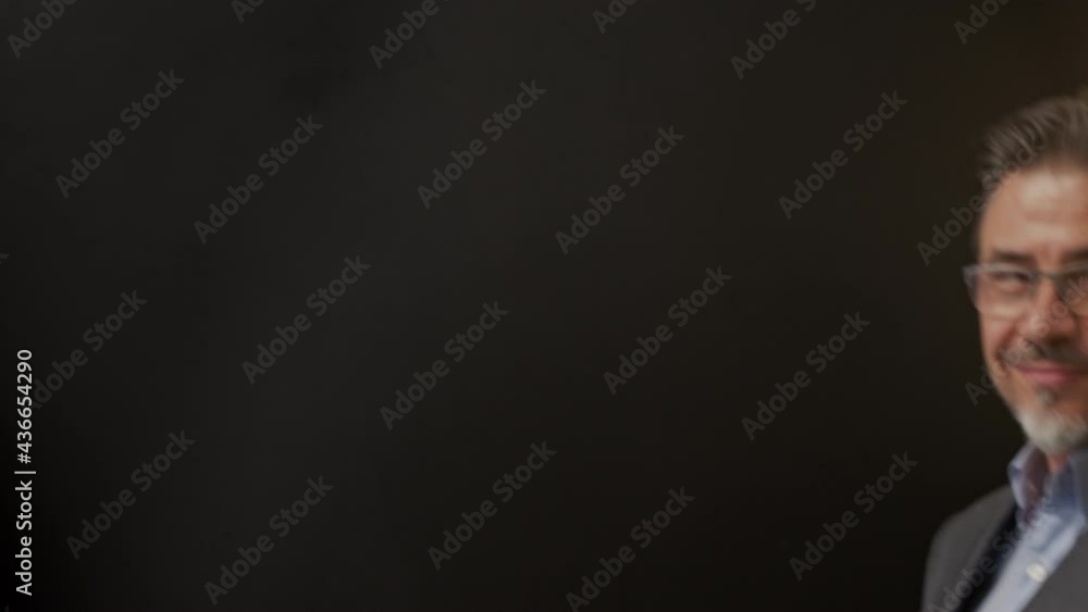 Business portrait - businessman smiling, pointing showing at blank space. Portrait of mature age, middle age, mid adult man in 50s, happy confident smile. Copy space. Business portrait - businessman smiling, pointing showing at blank space. Portrait of mature age, middle age, mid adult man in 50s, happy confident smile. Copy space.