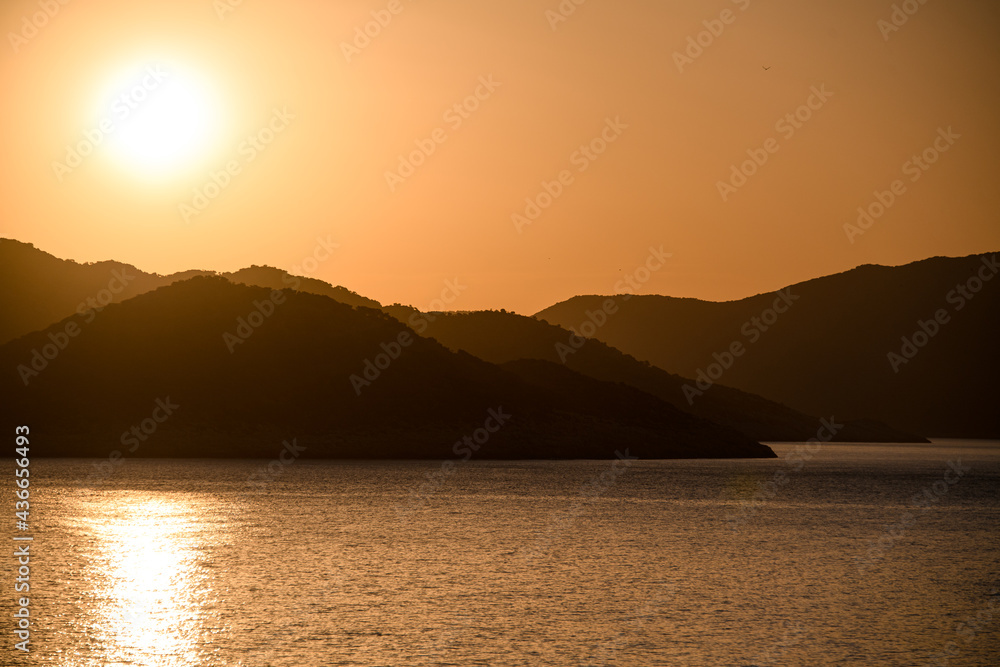 Beautiful mountainous landscape with sea at sunset.