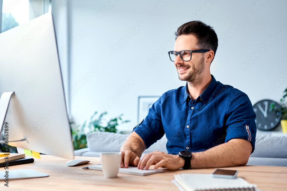 Successful young man working on computer from home Successful young man working on computer from home