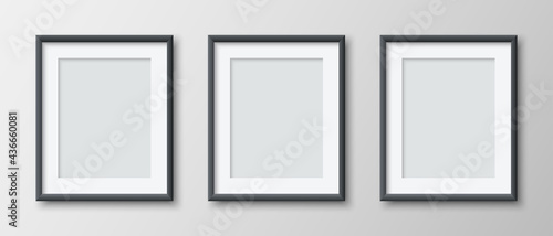 Realistic set of three vertical blank picture frame isolated on grey wall background. Empty photo frames set mockup for pictures, photograph, poster. Decorative design element interior. Vector