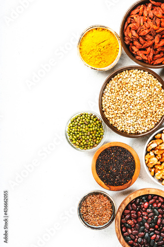 Set of superfoods, legumes, cereals, nuts, seeds in bowls on white background. Superfood as chia, spirulina, beans, goji berries, quinoa, turmeric and other. Copy space, top view