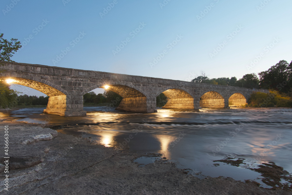 A lit up bridge spanning a river