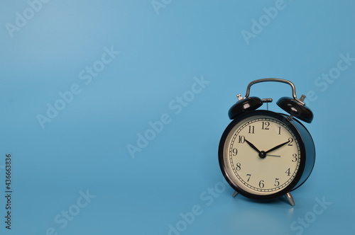 Alarm clock isolated on blue background with copy space