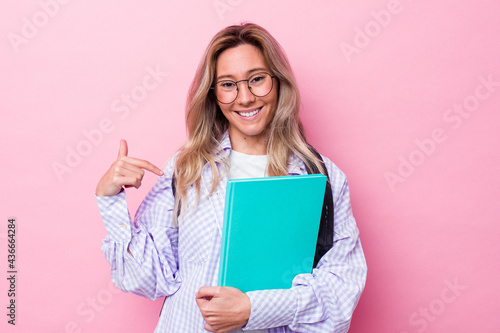 Young student australian woman isolated on pink background person pointing by hand to a shirt copy space, proud and confident