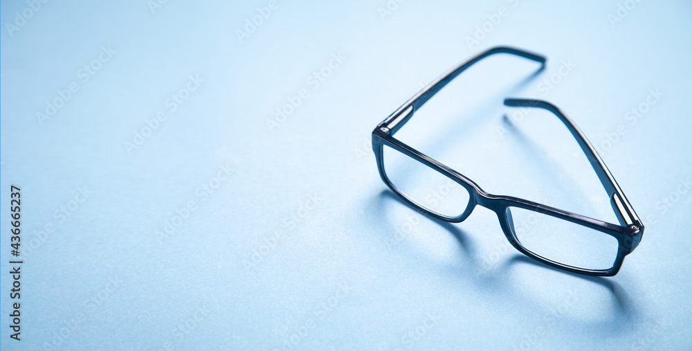Black eyeglasses on the blue background. Black eyeglasses on the blue background.