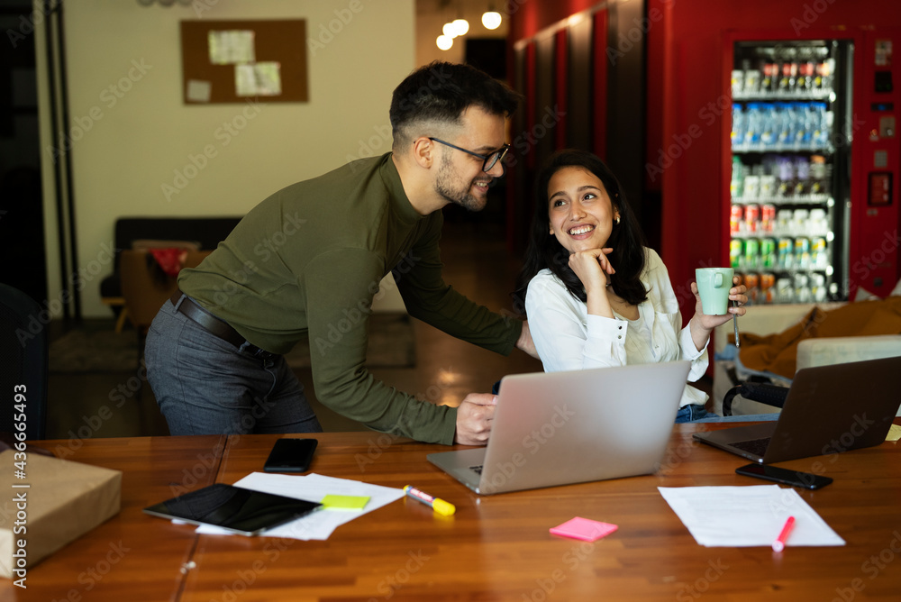 Colleagues drinking coffee in office. Businesswoman and businessman enjoying in fresh coffee