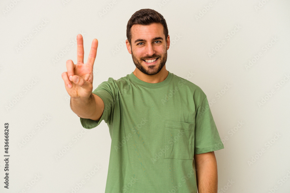 Young caucasian man isolated on white background showing victory sign and smiling broadly. Young caucasian man isolated on white background showing victory sign and smiling broadly.