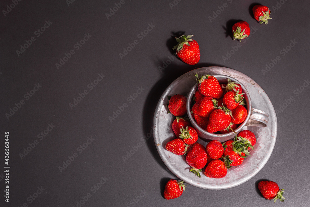 Concept of summer food with a strawberry on a black stone background Concept of summer food with a strawberry on a black stone background