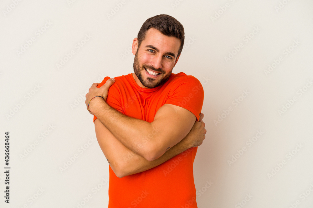 Young caucasian man isolated on white background hugs, smiling carefree and happy.